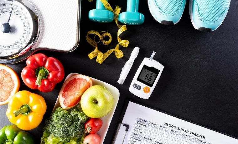 Healthy weight loss diet plan for diabetic patients with fresh fruits, vegetables, glucose meter, dumbbells, and meal tracker for blood sugar control.